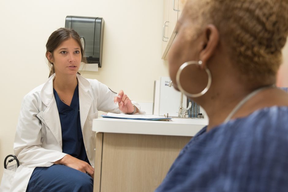 A primary care physician consulting with a patient at a medical clinic, discussing treatment and care options.