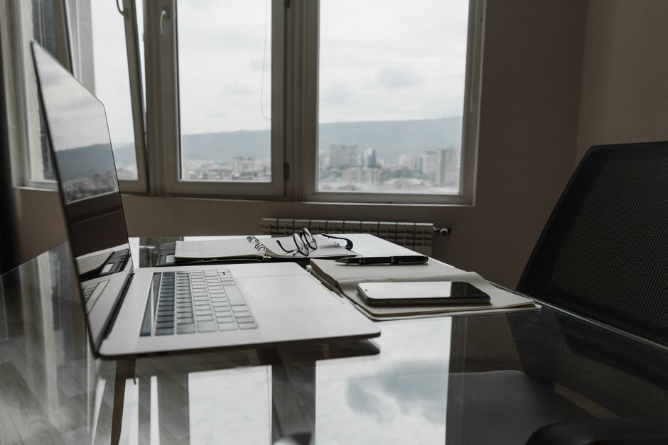 Open notebook and pencil on a wooden desk near a bright window